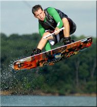 A boy in the air on a wakeboard over the water