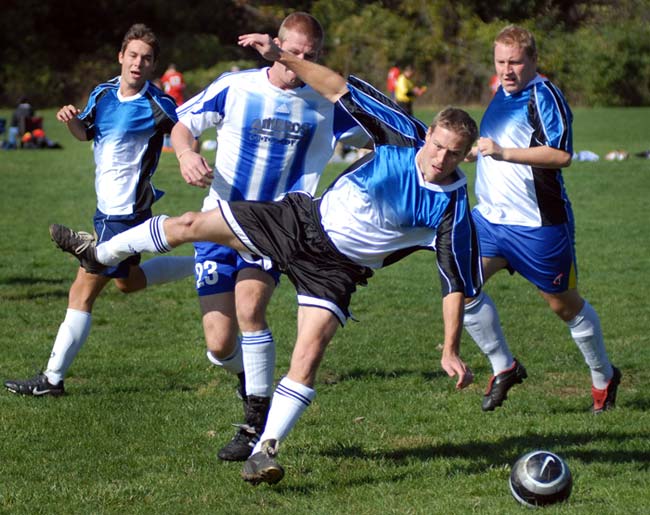 Soccer players in blue going ager the ball